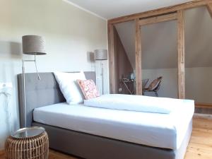 a bedroom with a large white bed in a room at Tauber Lodge in Creglingen
