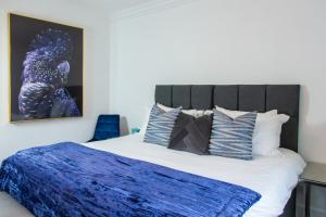 um quarto com uma cama com um cobertor azul em The Courtyard Lymm em Lymm