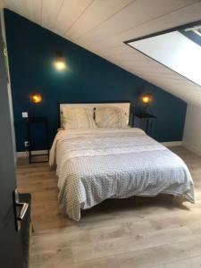 ein Schlafzimmer mit einem großen Bett mit blauer Wand in der Unterkunft Le Ristouar Spa forêt et mer in Quimperlé