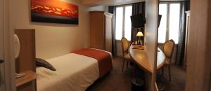 a hotel room with a bed and a desk at Hôtel Du Midi Paris Montparnasse in Paris