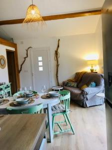 - un salon avec une table et un canapé dans l'établissement Cottage Combet Gîte Climatisé avec Jacuzzi, à Marsanne