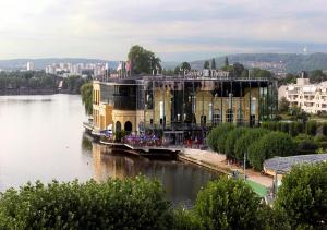 a large building on the water next to a river at Promotion du jour - Le Cerisier - in Deuil-la-Barre