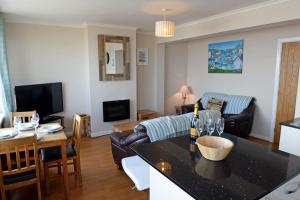 a living room with a couch and a table at Mermaid Apartment - Sea Front Apartment with Views in Saundersfoot