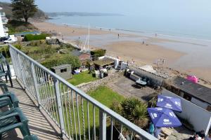 a balcony with a view of a beach with umbrellas at Mermaid Apartment - Sea Front Apartment with Views in Saundersfoot