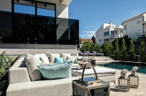 a couch sitting on a patio next to a pool at Deluxe Villa Curiera in Malinska