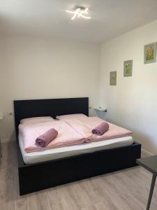 een bed met roze lakens en paarse kussens erop bij Al Tiglio Rooms in La Valle