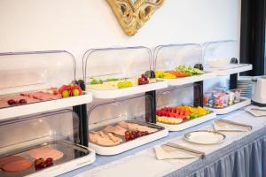 a buffet with several trays of food on a table at Hotel Astoria am Urachplatz in Stuttgart