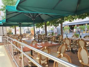 a patio with tables and chairs and a green umbrella at ibis Paris Bastille Opera in Paris