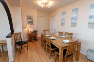 comedor con mesa de madera y sillas en Sea View Apartment - Sea Front Apartment with Views en Saundersfoot