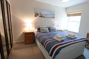 1 dormitorio con 1 cama con toallas en Sea View Apartment - Sea Front Apartment with Views en Saundersfoot