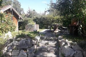 a garden with a stone walkway and a table and a fence at Andermichlhof (3)Ferienwohnung Groß Landsberger Strasse 8 in Geltendorf