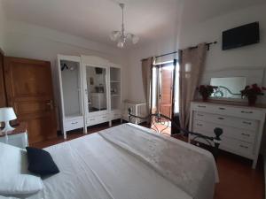 a bedroom with a large white bed and a dresser at La Cupoletta -Holiday House - GILDA in Trevignano Romano