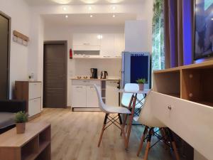 a kitchen and living room with a table and chairs at Comfort Apartment by Prima Lodging in Thessaloniki