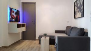 ein Wohnzimmer mit einem Sofa und einer lila Tür in der Unterkunft Comfort Apartment by Prima Lodging in Thessaloniki