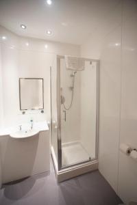 a white bathroom with a shower and a sink at Shah of Persia, Poole by Marston's Inns in Poole