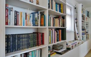 a book shelf filled with lots of books at The Cottage - Sea Views, Direct Access to Beach, Pet Friendly in Stepaside