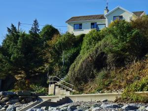 a house on the side of a hill at The Cottage - Sea Views, Direct Access to Beach, Pet Friendly in Stepaside