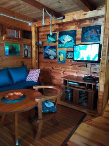 sala de estar con sofá, mesa y TV en Holiday Home Bojanka, en Ulcinj