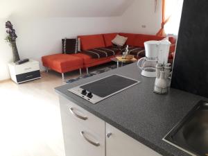 kuchnia i salon z czerwoną kanapą w obiekcie Ferienwohnung Am Sonnenweg w mieście Stanz Im Murztal
