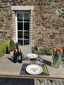einen Tisch mit einem Teller mit Speisen und Weinflaschen in der Unterkunft La Majolique in Namur