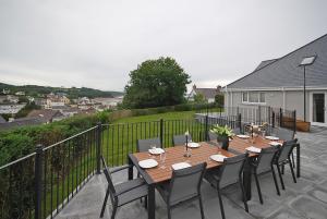 a wooden table and chairs on a patio at The Hawthorns - Large Luxury Cottage, Hot Tub, Sea Views in Saundersfoot