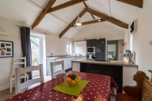Una cocina con una mesa con un bol de fruta encima. en The Dairy - Luxury Cottage, Hot Tub and Summer House, Countryside Views, Pet Friendly, en Ludchurch