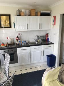 uma cozinha com armários brancos e um lavatório em Sunset Valley em Dartmouth