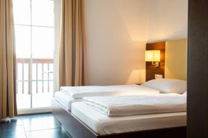 um quarto de hotel com duas camas e uma janela em Residence Saalbach by VAYA em Saalbach-Hinterglemm