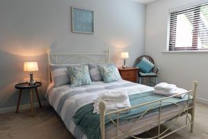 a bedroom with a bed and two tables and two lamps at Valley Retreat - Peaceful Location, Walk to Beach, Parking in Saundersfoot