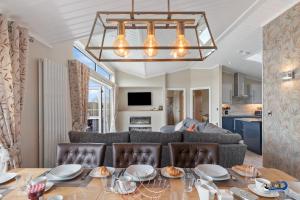 a dining room and living room with a table and chairs at Valley View Lodge - Luxury Lodge, Hot Tub, Close to Beach in Penally