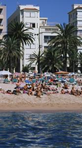 a crowd of people on a beach near the water at Hotel Maeva ,1 star B&B in Lloret de Mar