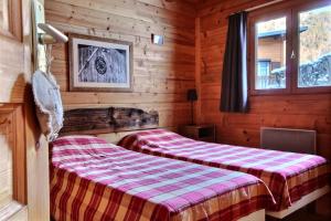 a bedroom with two beds in a log cabin at Appartement à 600m des remontées mécaniques, centre Morzine, chalet les Joux in Morzine