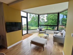 a living room with large windows and a tv at Domaine de Stang Bihan in Concarneau