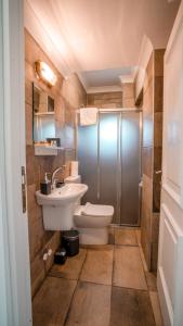 een badkamer met een toilet, een wastafel en een douche bij Camlik Deniz Yildizi Hotel in Ayvalık