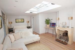 a living room with a white couch and a fireplace at Aan Zee en Duin in Egmond aan Zee