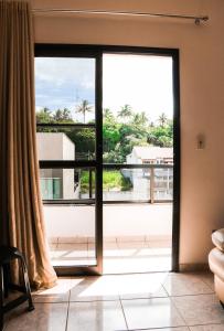 Une porte ouverte s'ouvre sur un balcon avec vue. dans l'établissement Ótimo apartamento na Praia dos Castelhanos com Wi-Fi, à Anchieta