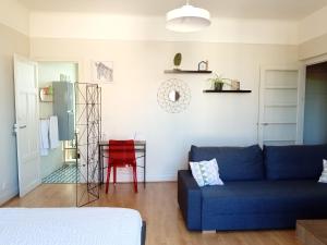a living room with a blue couch and a red table at Les Cocons avec balcon in Vichy