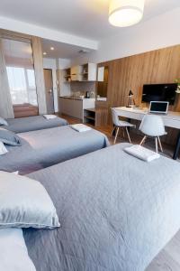 ein Hotelzimmer mit 2 Betten und einem Schreibtisch mit einem Laptop in der Unterkunft Wolska Residence I in Warschau