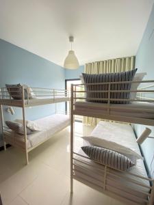 um quarto com 2 beliches e almofadas em Bordal Houses Casa da Areia em Porto Santo