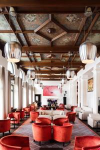 a lobby with red chairs and a waiting room at The Dolder Grand - City and Spa Resort Zurich in Zürich
