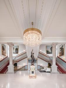 a large room with stairs and a chandelier at The Dolder Grand - City and Spa Resort Zurich in Zurich