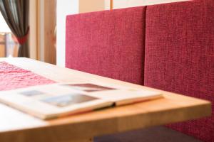 un libro sentado en una mesa de madera junto a una cama en Haus Sonnegg Familiensuite, en Laion