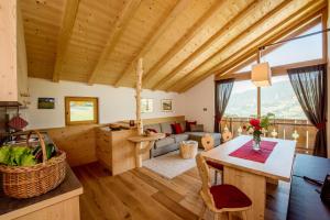 cocina y sala de estar con techo de madera en Haus Sonnegg Familiensuite, en Laion
