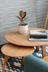 a wooden table with a vase on top of it at COVE Cannon Street in London