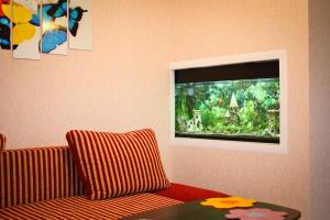 sala de estar con sofá y TV de pantalla plana en Vesela Bdzhilka en Sumy