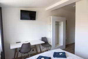 a bedroom with a bed and a desk and two chairs at Novohradská in České Budějovice