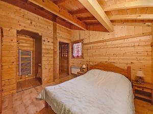a bedroom with a bed in a log cabin at CHALET-MORZINE-6 a 18 PERSONNES-SAUNA -PROCHE NAVETTE et BOULANGERIE-MANUPA CLEVIE in Morzine