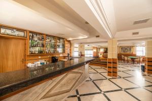 eine Lobby mit einer Bar und einem Essbereich in der Unterkunft Hotel Baía De Monte Gordo in Monte Gordo