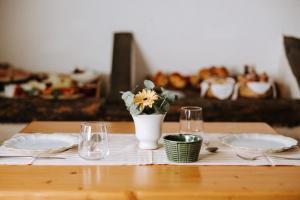 einen Tisch mit zwei Platten und eine Vase mit Blumen in der Unterkunft Masseria Garrappa in Fasano