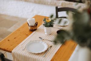 a wooden table with plates and a plant on it at Masseria Garrappa in Fasano